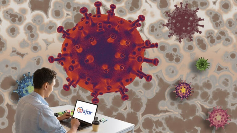 Un homme derrière son ordinateur devant un gros virus