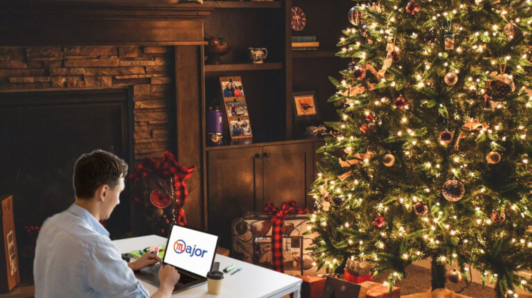 Un homme en train de travailler devant un sapin de Noël