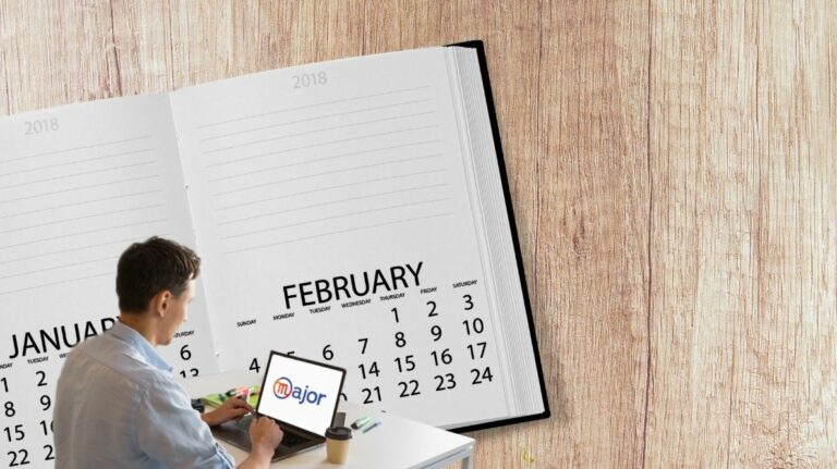 Un homme en train de travailler devant un agenda du mois de février