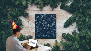Un homme en train de travailler devant un panneau "Happy Holidays"