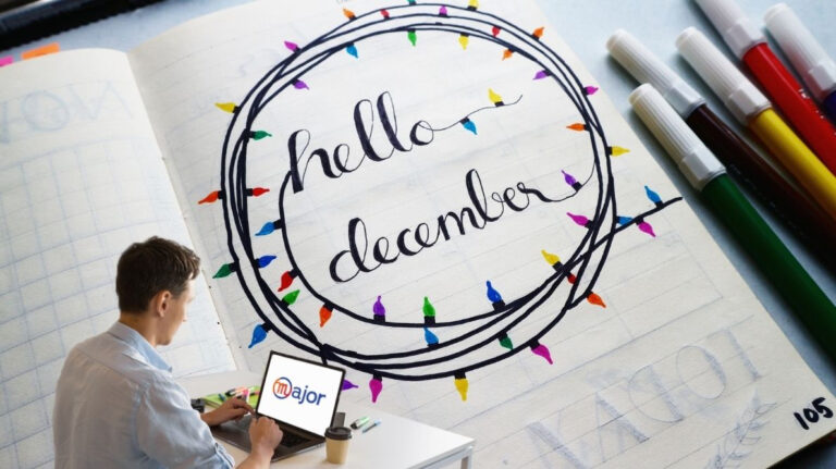 Un homme derrière son ordinateur devant un agenda indiquant "hello december"