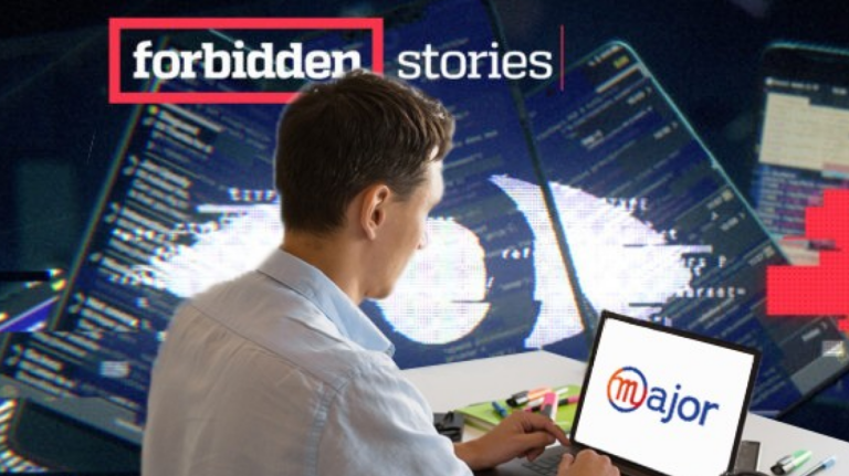 Un homme tapant à l'ordinateur devant une photo "Forbidden stories"