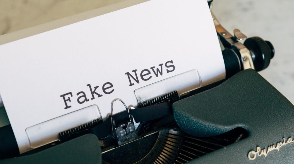 Une machine à écrire avec une feuille de papier sur laquelle est écrite "fake news"