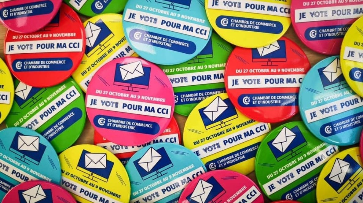 Photo de plusieurs badges ronds avec écrit "JE VOTE POUR MA CCI"