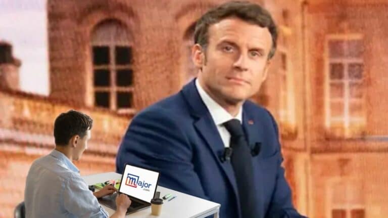 Un homme travaillant sur un ordinateur devant un portrait d'Emmanuel Macron