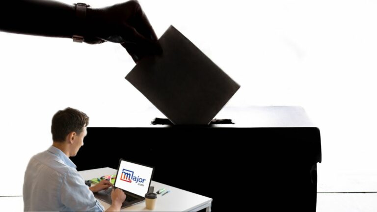 Un homme travaillant sur son ordinateur devant un bulletin de vote