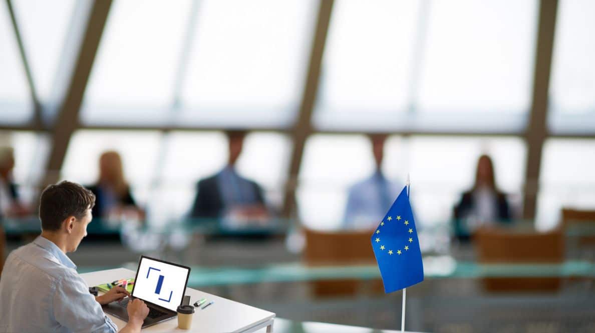 Un homme en train de travailler sur son ordinateur à la table de la Commission européenne