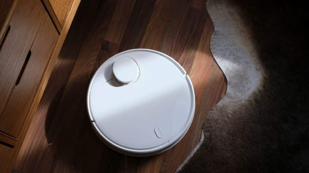 Aspirateur robot à côté d'un tapis