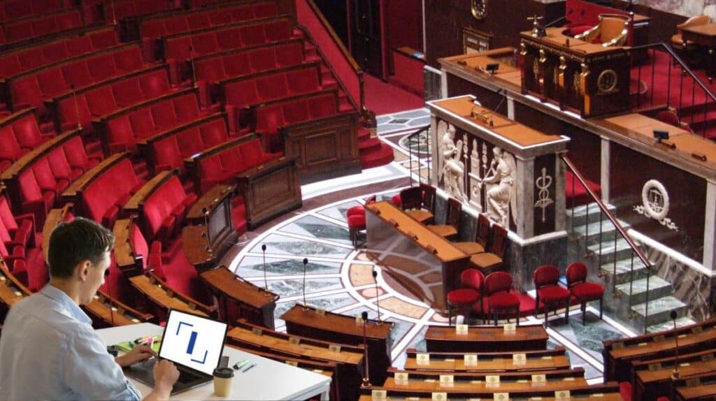 Un homme travaillant sur un ordinateur portable dans l'hémicycle de l'assemblée nationale