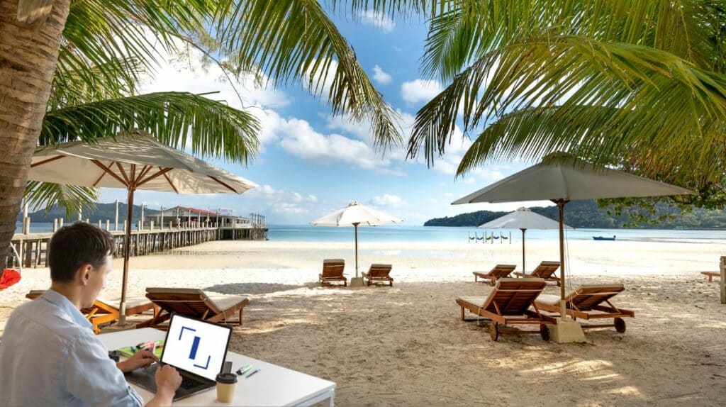 Un homme à la plage travaillant sur son ordinateur